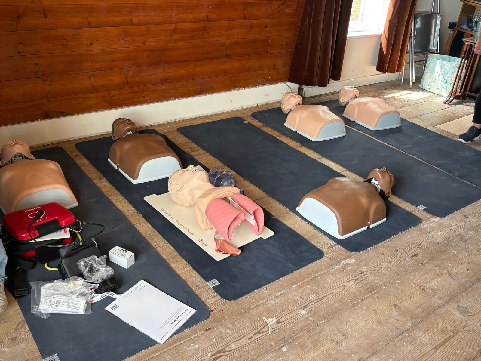 Resuscitation manikins, AED and airway management trainer laid out for the session